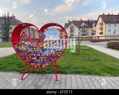 Breslau, Polen 31. März 2021: Sammelplatz für bunte Plastikflaschen-Kappen für Recycling und Wohltätigkeitsorganisationen. Herzförmiger Metallbehälter. Stockfoto