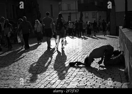 Prag, Tschechische Republik - 23 2019. August: Schwarz-Weiß-Bild der Atmosphäre auf der Karlsbrücke mit einem Obdachlosen, der um Geld bettelte Stockfoto