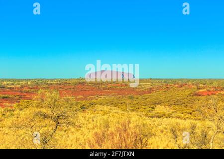 Uluru oder Ayers Rock in der Ferne im Uluru-Kata Tjuta National Park vom Aussichtspunkt der Dünenlandschaft im Northern Territory, Australien. Australien Stockfoto