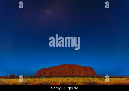 Uluru bei Nacht mit hellen Sternen am Himmel. Sternenhimmel im Uluru-Kata Tjuta National Park im Northern Territory, Zentralaustralien. Großer Kopierspeicher. Stockfoto