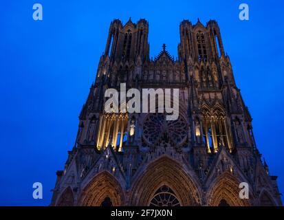 Kathedrale von Reims Notre Dame zur blauen Stunde. Abends bunte Beleuchtung der Fassade. Reims, Champagne, Frankreich. Stockfoto