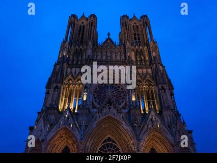 Kathedrale von Reims Notre Dame zur blauen Stunde. Abends bunte Beleuchtung der Fassade. Reims, Champagne, Frankreich. Stockfoto