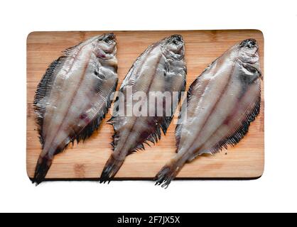 Roher Flunder Fisch, Meeresfrüchte auf einem Holzbrett isoliert auf weißem Hintergrund. Gesunde Ernährung Konzept. Draufsicht Stockfoto