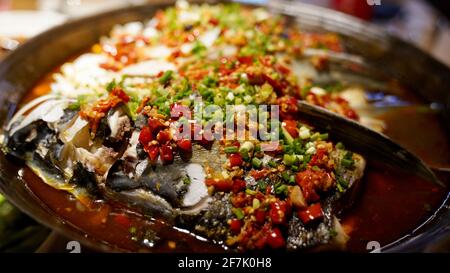 Gedünsteter Fischkopf mit gewürfelten roten Paprika. Stockfoto