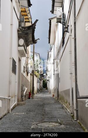 Ein enger Weg zwischen Häusern mit weißen Mauern in einer Altstadt. Stockfoto