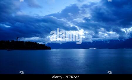 Erhai See in Dali mit bewölktem Himmel mit blauem Himmel bei Einbruch der Dunkelheit, mit einer Insel weit weg. Stockfoto