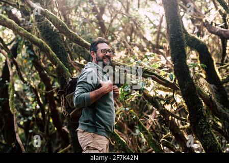 Stehender Reisender bärtiger Mann spazieren und genießen die freie Natur Wald in Trekking-Aktivität - Konzept der schönen männlichen Menschen Erkunden Sie die Wälder mit dem Rücken Stockfoto