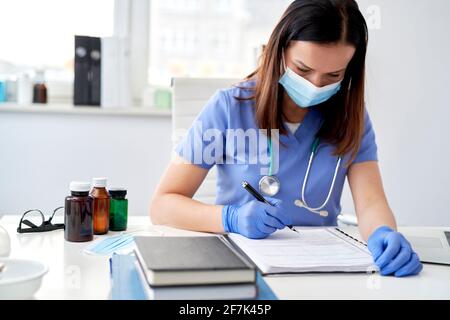 Ärztin beim Ausfüllen von Krankenakten Stockfoto