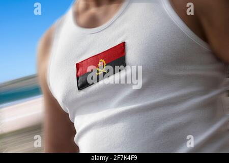 Die Nationalflagge von Angola auf der Brust des Athleten Stockfoto