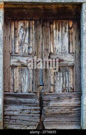 Alte Holztür in Italien mit Eisenschiebeschloss Detail. Speicherplatz kopieren. Stockfoto
