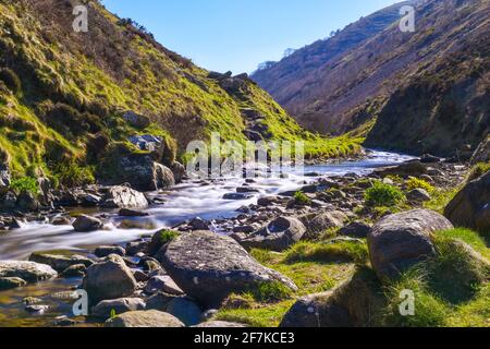 Rauschende Flusswasser über Felsen und Felsbrocken in einer landschaftlich reizvollen Umgebung Tal auf dem Land Stockfoto