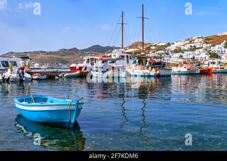 Schöner Sommertag im typischen Yachthafen der griechischen Insel. Fischerboote, Yachten per Steg. Weiß getünchte Häuser. Kleines Boot. Mykonos, Kykladen, Griechenland. Stockfoto