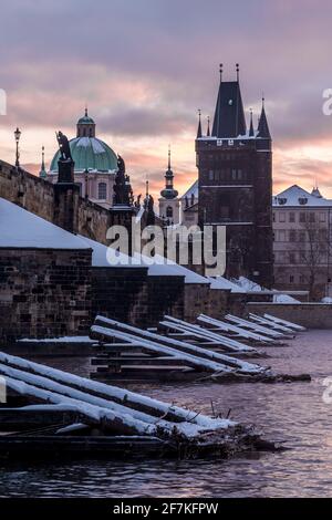 Karlsbrücke in Prag bei winterlichen Sonnenaufgängen, bewölkt mit Moldau in Sicht Stockfoto