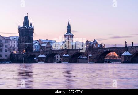 Karlsbrücke in Prag bei winterlichen Sonnenaufgängen, bewölkt mit Moldau in Sicht Stockfoto