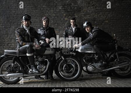 Rocker Gang posiert mit britischen Klassiker Triumph, Triton Motorräder. Rocker auf klassischen Cafe Racer-Motorrädern in London, Großbritannien. Stockfoto