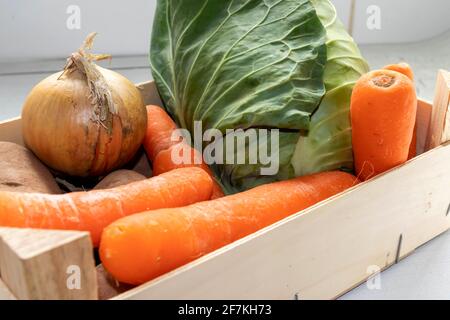 Eine Holzkiste mit frischem Gemüse auf einer Küchentisch Oben Stockfoto