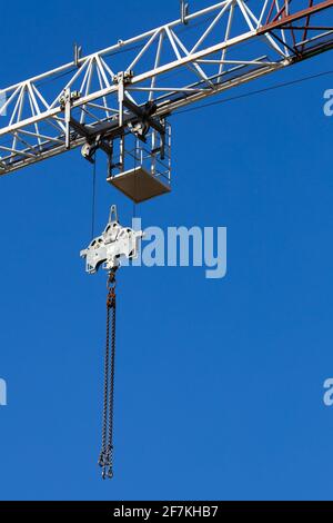 Details des Baukran vor dem Hintergrund des blauen Himmels. Krankette und Riemenscheibensystem. Foto aufgenommen an einem sonnigen Tag. Stockfoto