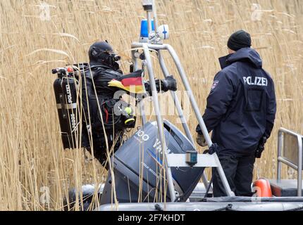 08. April 2021, Brandenburg, Flieth-Stegelitz/GT Suckow: Ein Taucher der Brandenburger Polizei steigt nach dem ersten Tauchgang im Oberuckersee wieder in das Schlauchboot ein. Fünf Leichen sollen vor 20 Jahren im nordöstlichen See Berlins abgeladen worden sein. Der mutmaßliche Mörder ist inzwischen verstorben. Die Polizeitaucher suchen seit Sommer 2020 nach den Toten. Foto: Soeren Sache/dpa-Zentralbild/dpa Stockfoto