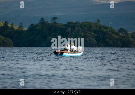 Irland Fliegenfischen. Erwachsene Männer und Jungen fischen von einem Boot in den Killarney Lakes im Killarney National Park, County Kerry, Irland Stockfoto