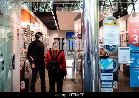 Porto, Portugal. April 2021. Menschen mit Gesichtsmask werden gesehen, die darauf warten, einen Laden in Porto zu betreten. Die zweite Phase des Definationsprozesses in Portugal begann am 5. April. Restaurants und Cafés durften Menschen auf den Tischen im Freien in Gruppen von 4 Personen pro Tisch beherbergen und die Menschen können nun mit mehr Freiheit durch die Stadt gehen. Kredit: SOPA Images Limited/Alamy Live Nachrichten Stockfoto