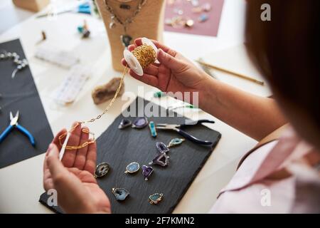 Handwerker, der das Material für einen Anhänger auswählt Stockfoto