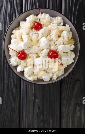 Glorified Reis ist ein Dessertsalat, der in der Küche des Mittleren Westens beliebt ist und in Minnesota und anderen Staaten in Nahaufnahme auf einem Teller auf dem Tisch serviert wird. Vertikal zu Stockfoto