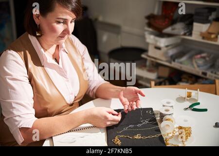 Die Kunsthandwerkerin kreiert eine neue Kette für ihren Kunden Stockfoto