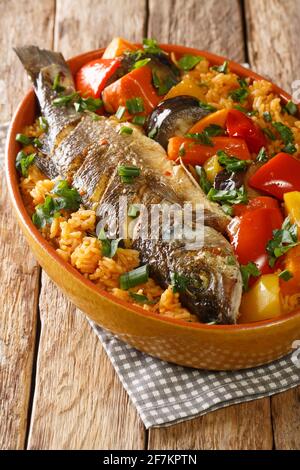 Thieboudienne Fisch und Reis die Nationalkost des Senegal in der Schale auf dem Tisch. Vertikal Stockfoto