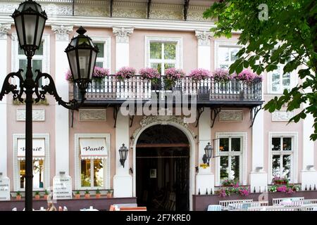 Odessa, Ukraine - 05.07.2019. Cafe auf der Straße der alten europäischen Stadt. Tische unter dem Himmel. Open-Air-Café. Balkon mit Blumen. Stockfoto