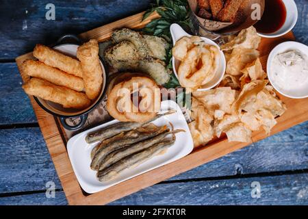 Snacks zu Bier auf blauem Holzhintergrund. Stockfoto