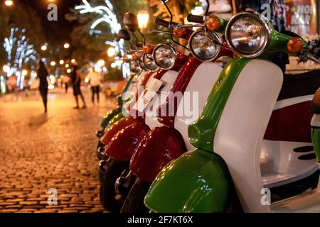 Motorroller-Verleih in der Nigth Street. Bunte Roller auf der Touristenstraße. Parkplatz für Mietwagen. Stockfoto
