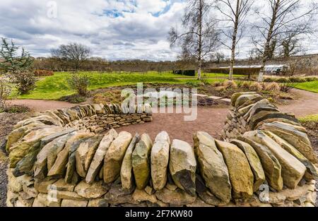 Runder, von Trockensteinen gemauerter Sitzbereich und Teich, von Amisfield gemauerter Garten, East Lothian, Schottland, Großbritannien Stockfoto