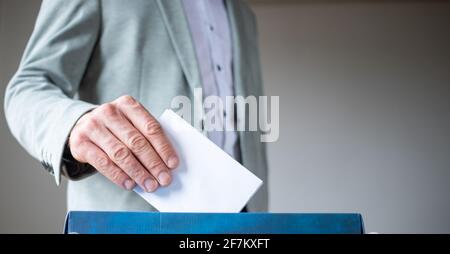 Männliche Hand, die die Stimme in die Abstimmung einbringt Stockfoto