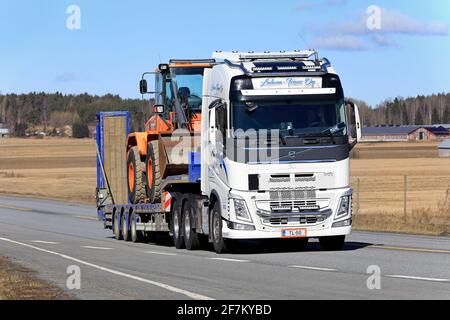 Volvo FH 540 LKW von Lahma-Trans Oy transportiert Doosan Radlader auf Tieflader entlang der Autobahn im Frühjahr. Jokioinen, Finnland. April 2021. Stockfoto