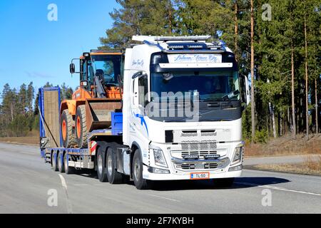 Volvo FH 540 LKW von Lahma-Trans Oy transportiert Doosan Radlader auf Tieflader entlang der Autobahn im Frühjahr. Jokioinen, Finnland. April 2021. Stockfoto