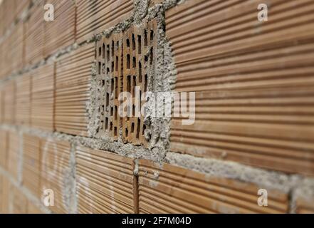 Wanddetail mit Terrakotta-Backsteinfassade Stockfoto