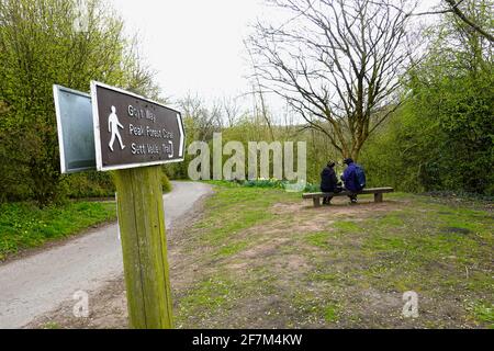 Ein Paar ruht auf einem Sitzplatz in der Nähe des Flusses Goyt in New Mills, Derbyshire Stockfoto