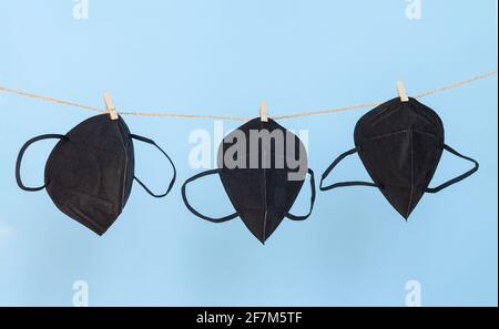 Waschbare Gesichtsmasken aus schwarzem Schutzgewebe, zum Schutz vor Viren, an Wäscheleine hängend Stockfoto
