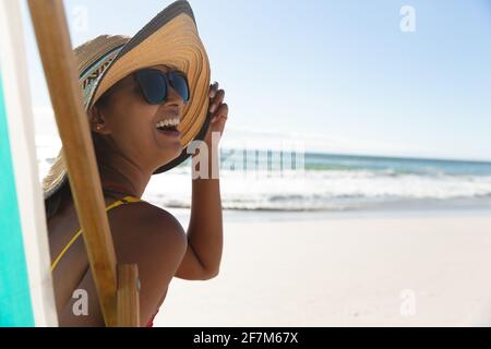 Gemischte Rennen glückliche Frau am Strand Urlaub sitzt in Liegestuhl Stockfoto