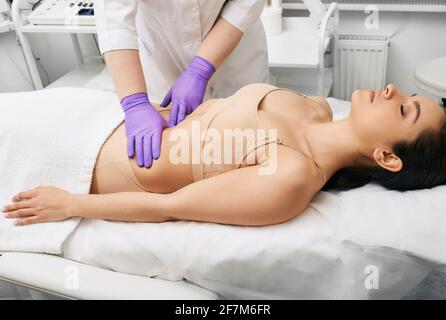 Ärztliche Untersuchung. Arzt zur Vorsorgeuntersuchung eines weiblichen Abdomens zur Untersuchung der inneren Organe der Frau Stockfoto