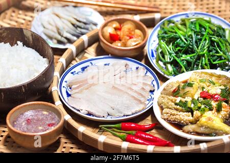 Vietnamesisches Familienmittagessen mit gekochten Schweinefleischscheiben Shrimp Paste Sauce und Beilagen Stockfoto