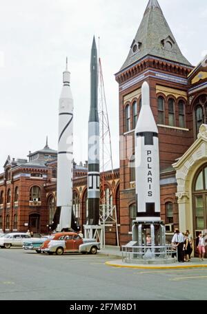 ‘Rocket Row’ entlang der Westseite des Arts and Industries Building (vor dem Bau des National Air and Space Museum), Washington DC, USA, im Jahr 1964. Die vier Raketen sind der Jupiter C, der Explorer I, den ersten US-Satelliten (links), die Vanguard (Mitte) und die Polaris A-1, die erste US-U-Boot-gestartete ICBM (rechts), startete. Autos werden auf dem Parkplatz abgestellt. Das Air and Space Museum wurde ursprünglich als National Air Museum bezeichnet, als es 1946 gegründet wurde. Dieses Bild stammt von einem alten amerikanischen Amateur Kodak Farbtransparenz – einem alten Foto aus den 1960er Jahren. Stockfoto