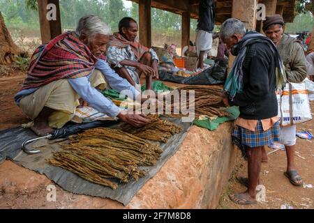 Laxmipur, Indien - Februar 2021: Männer verkaufen Tabakblätter auf dem Wochenmarkt in Laxmipur am 20. Februar 2021 in Odisha, Indien. Stockfoto