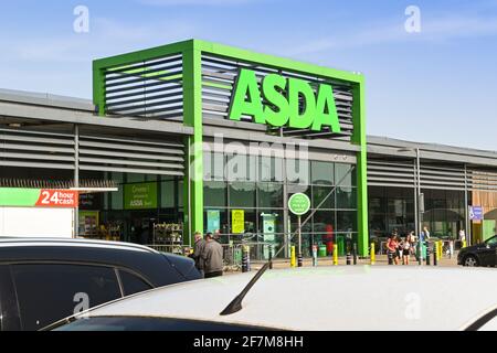 Barry, Wales - März 2021: Großes Schild über dem Eingang einer Niederlassung von Asda in Barry, Südwales, mit Autos, die im Vordergrund geparkt sind. Stockfoto