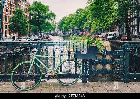 Amsterdam Kanal mit Booten und Fahrrädern auf einer Brücke Stockfoto