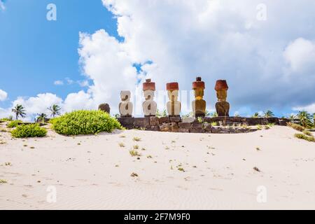 Rückansicht der Köpfe von restauriertem Moai mit roten Skorienknoten (Pukao) auf Ahu Nao-Nao, Anakena Beach an der Nordküste der Osterinsel (Rapa Nui) Stockfoto