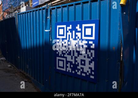 Blauer QR-Code auf einer Baustelle, die am 30. März 2021 in Birmingham, Großbritannien, hortet. Ein QR-Code ist eine Art Matrix-Barcode, der erstmals 1994 für die Automobilindustrie in Japan entwickelt wurde. Ein Barcode ist ein maschinenlesbares optisches Etikett, das Informationen über das Element enthält, an das er angebracht ist. Stockfoto