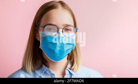 Neblige Brille trägt auf Frau. Frau Porträt in medizinischen Schutz Gesichtsmaske und Brillen wischt verschwommen neblig vernebelte Gläser auf rosa Farbe Backgro Stockfoto