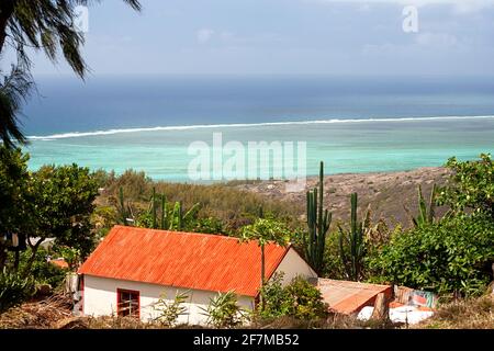 Kleines traditionelles Haus eines Fischers auf einer Insel Rodrigues im Indischen Ozean, Mauritius, mit einem spektakulären Korallenriff und einer Lagune im Hintergrund Stockfoto