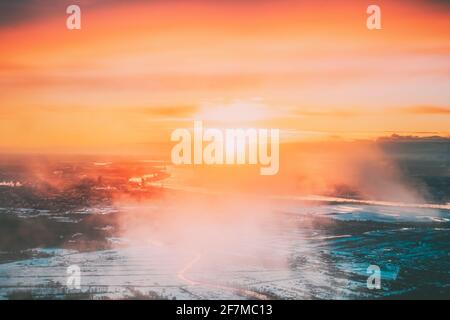 Luftaufnahme Des Sonnenaufgangs Über Der Stadt. Blick Vom Höhenflug Der Flugzeuge Auf Die Lettische Hauptstadt Riga Im Winter Bei Sonnenaufgang Bei Sonnenuntergang. Colourful Sky Und Stockfoto